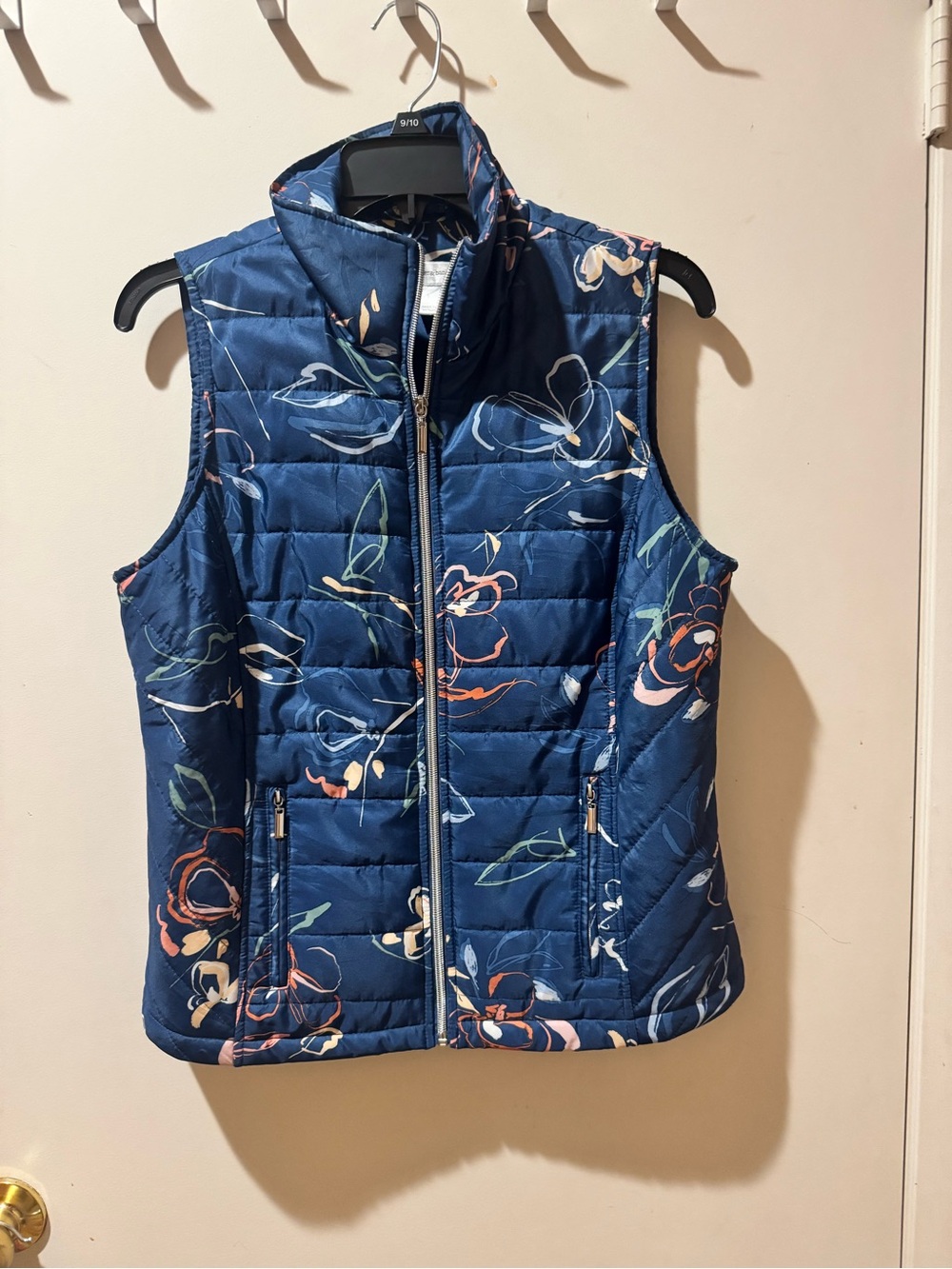 Lightweight vest with a navy floral print. Stand collar and full zip for easy